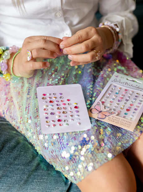 Nail Stickers | Butterfly showing colorful gemstone-style nail stickers on a sequin dress background.