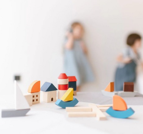 Marina Blocks wooden toy set with colorful sailboats, lighthouse, docks, and buildings for imaginative play.