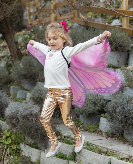 Young girl jumping outdoors wearing Soft Wings Mystical Monarch with vibrant pink and purple butterfly patterns.