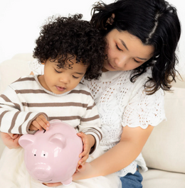Child and mother holding a pink Ceramic Piggy Bank | Pink, teaching savings with a durable glazed ceramic design.