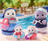 Seal Family plush figures with round features, marine-style clothes, and pool accessories by the water.
