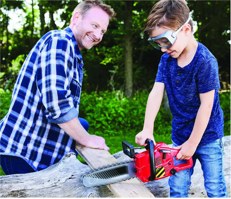 Child wearing goggles uses the Power Chainsaw toy outdoors while an adult watches, enjoying pretend play time together.