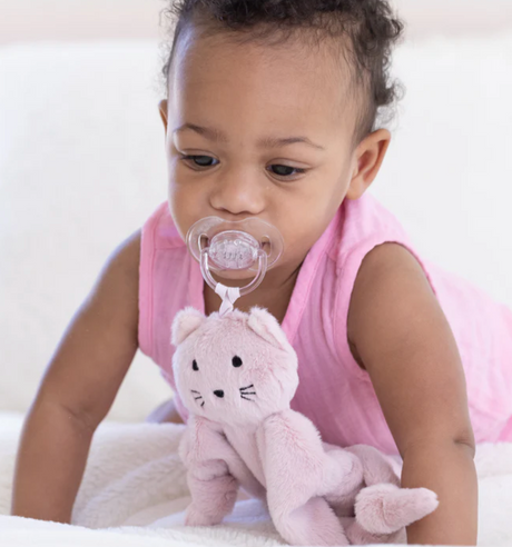 Baby with pacifier attached to soft pink plush cat in Pacifier Buddy | Charlotte the Cat, perfect lovey for infants.