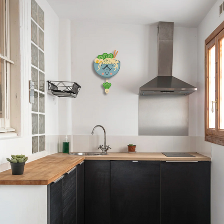 Wood Pendulum Clock | Ramen with smiling bok choy pendulum and noodle bowl design hanging in modern kitchen.