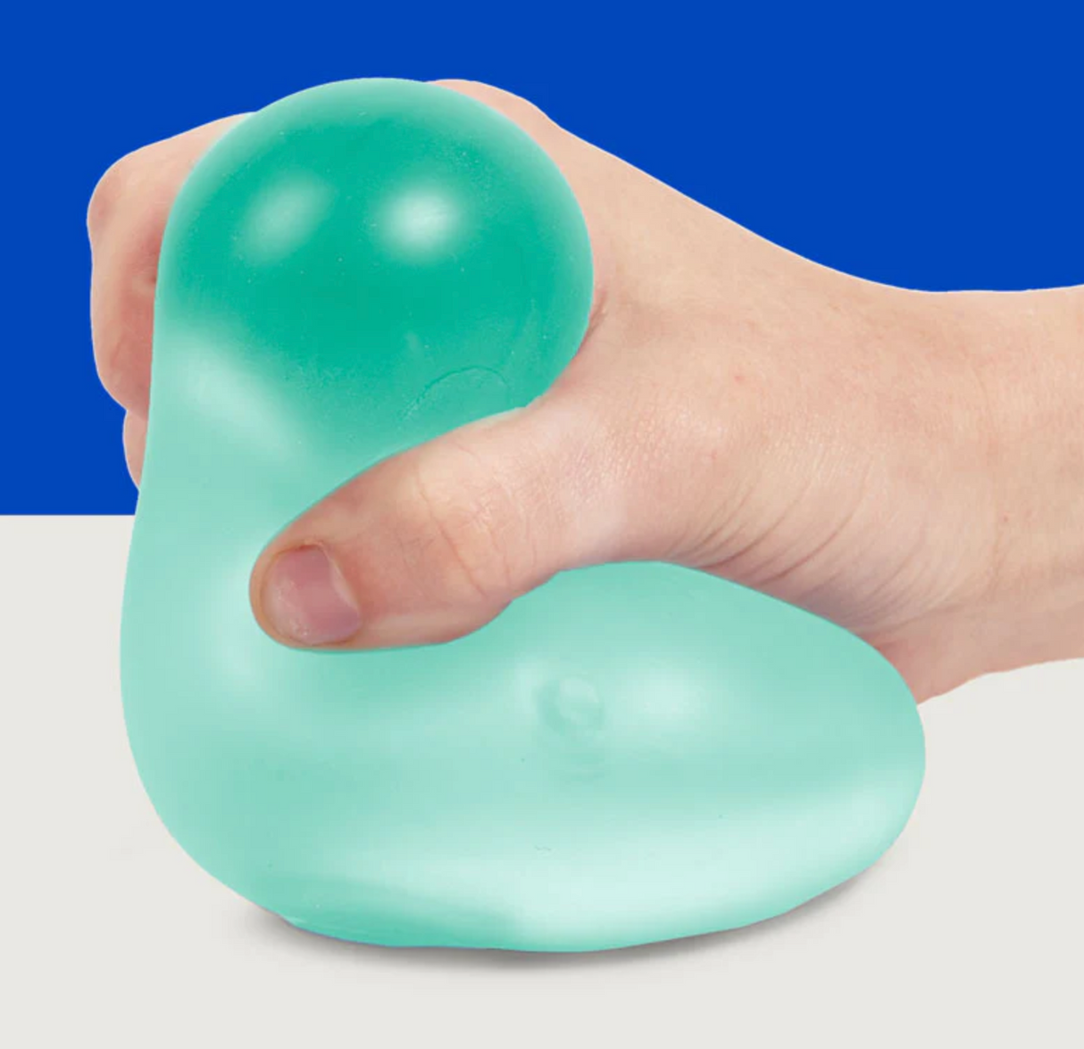 Hand squeezing soft, teal stress ball filled with goo in Speks. Gump Jumbo Sea, perfect for stress relief and desk use.