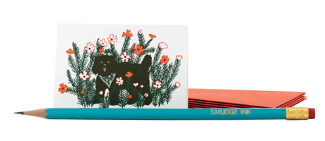 Mini Enclosure Card | Black Dog showing a small folded card with black dog and floral design next to a pencil and orange envelope.