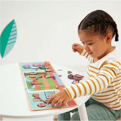 Child playing with MagnetiStories | Pets magnetic game featuring colorful pet magnets on a foldable illustrated board.