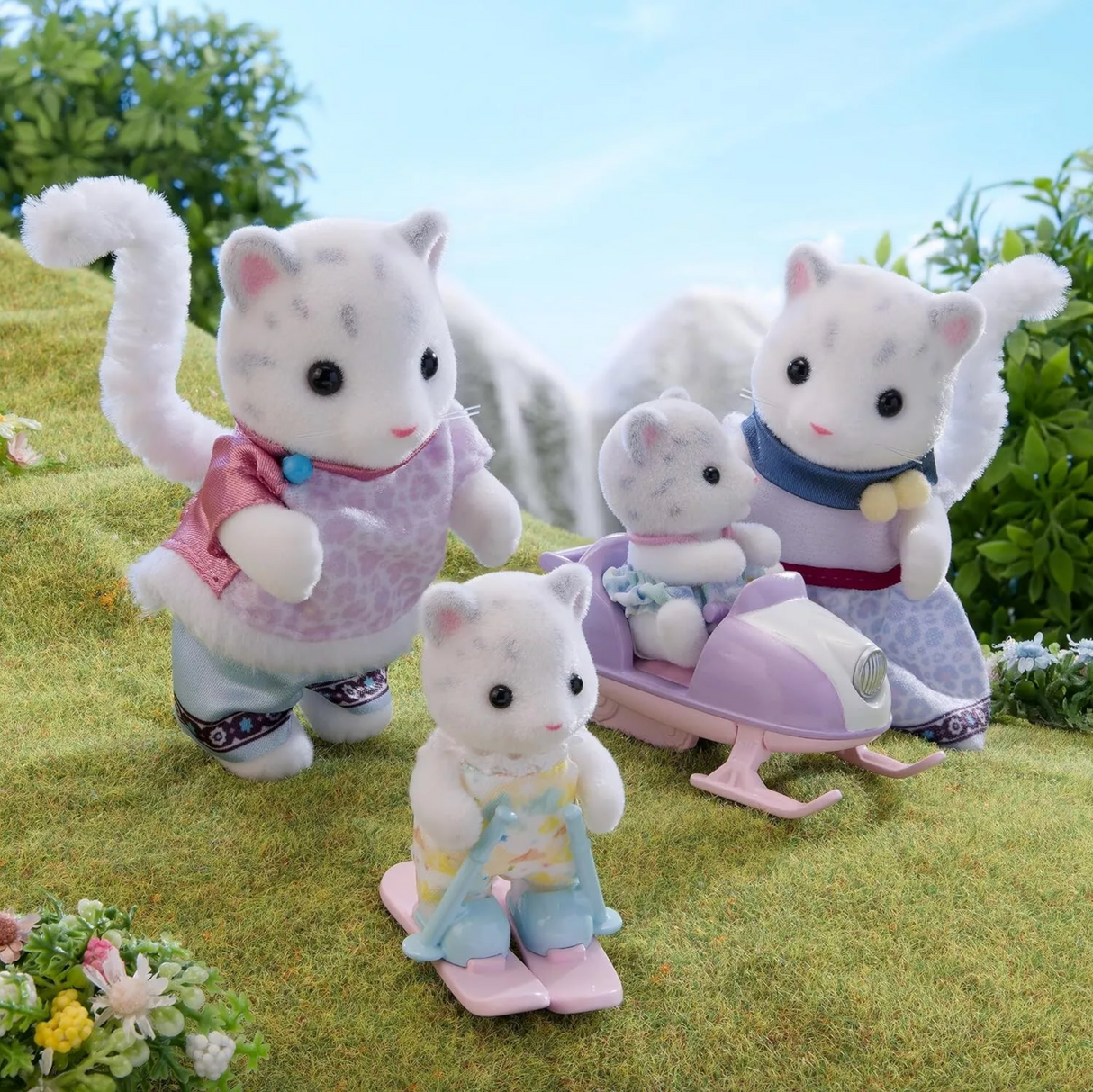 Snow Leopard Family figurines with two adults and two cubs playing outdoors on skis and a sled.