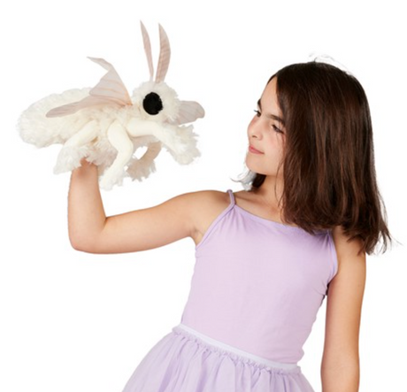 Girl in lavender dress holding a Poodle Moth Puppet with fluffy white body and large antennae.