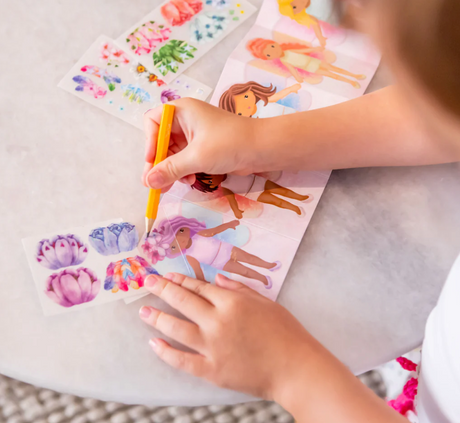 Child using Mini Transfer Magic | Flower Fairies to add floral designs to fairy templates with a pencil on a table.