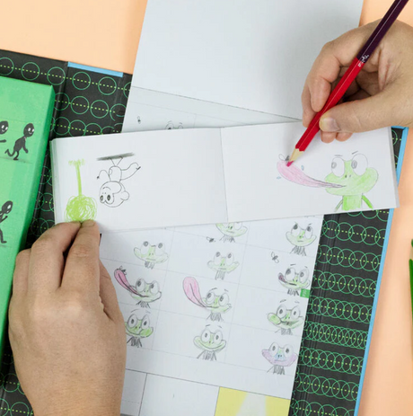 Hands drawing animated characters in a flip book from the Flip Book Kit | Animation in Action for kids learning animation.