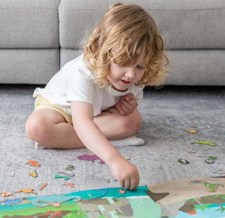 Child playing with magna carry | Dino World magnetic prehistoric puzzle set on the floor.