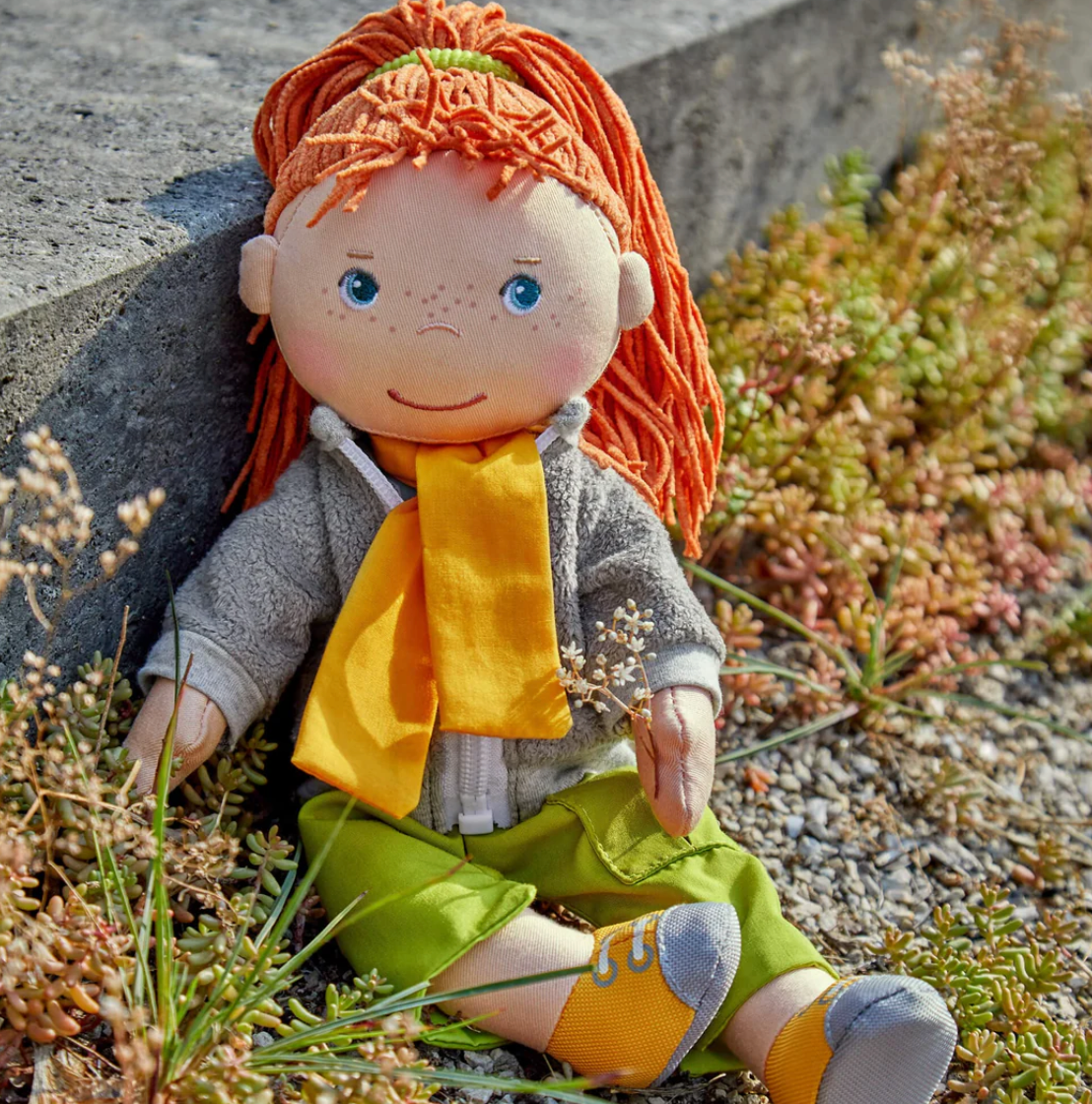 Soft Doll | Soley sitting outdoors wearing a yellow scarf, fleece jacket, green pants, and sporty shoes.