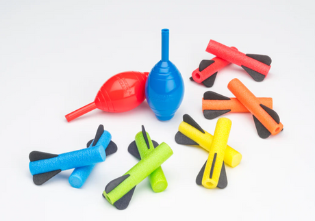 Squeeze Rockets set showing colorful foam rockets and two hand-held squeeze launch bulbs on a white background.
