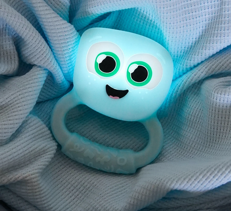 Glo Pals Light Up Rattle | Blue glowing softly on a textured fabric, perfect for baby sensory play.