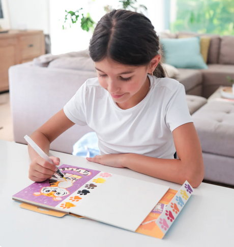 Child using the Paint a Picture Set | Wild Animals to paint a tiger with built-in watercolor palette and brush.