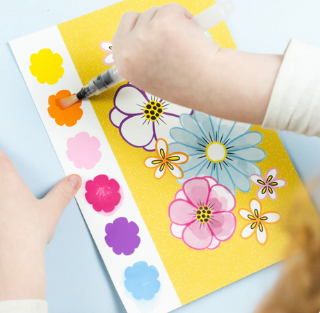 Child painting colorful flowers using waterbrush from Paint a Picture Set | Butterflies & Flowers on yellow page.
