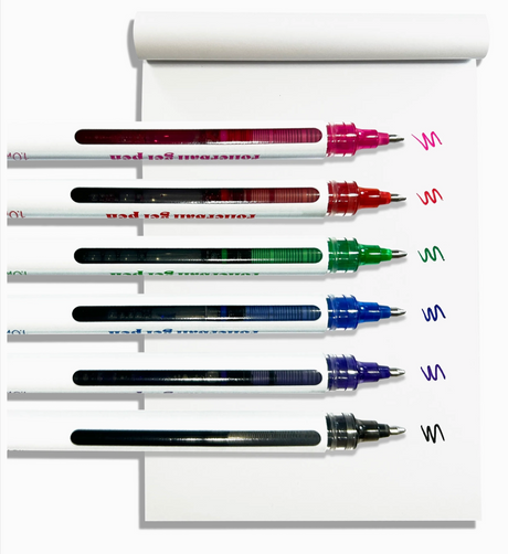 Six rollerball gel pens in vibrant colors writing smooth wavy lines on a white notepad with visible ink inside.