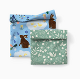 Two reusable snack pouches with bunny and botanical patterns, designed for eco-friendly lunch packing.