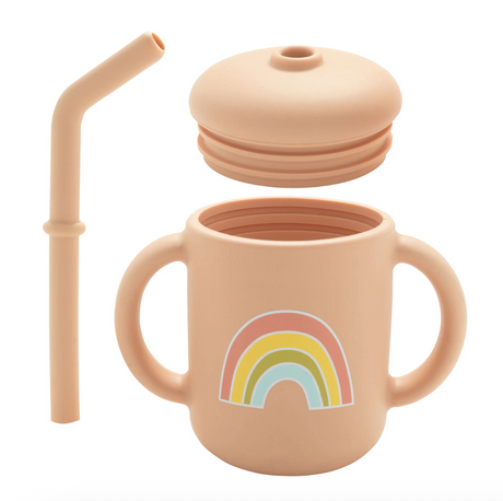 Peach-colored silicone sippy cup with two handles, removable lid, straw, and a pastel rainbow design on front.