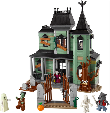 Two-story haunted mansion toy with spooky characters, boarded windows, graveyard, and eerie tree model for creative play.