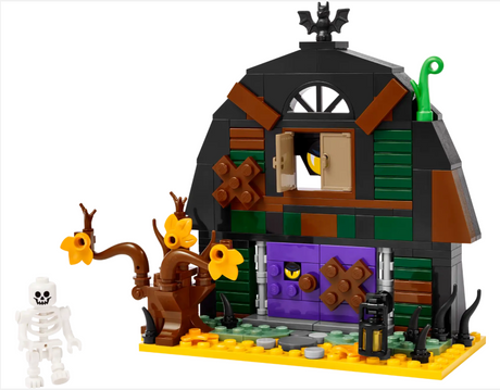 Small green and black barn with purple door, spooky tree, skeleton figure, and bat on roof toy set