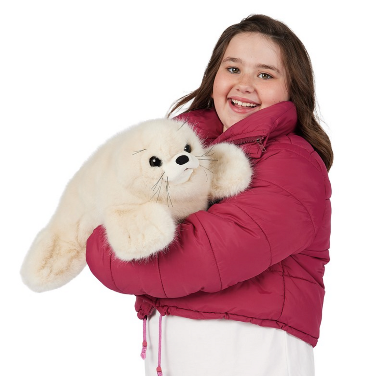 Girl smiling while hugging a soft harp seal pup puppet with black eyes and thick white fur