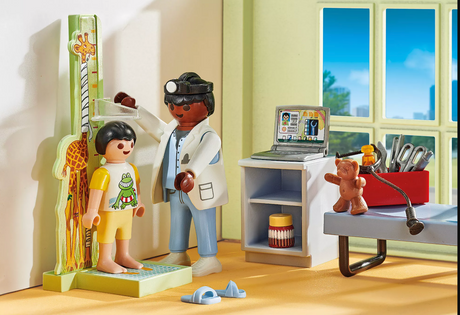 Pediatrician figure examining child figure’s casts with teddy bear and medical accessories in a bright playroom setting.