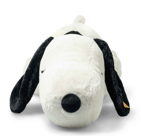Large plush Snoopy lying on his tummy with closed eyes and floppy black ears, smiling softly and peaceful.