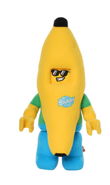 Soft plush toy shaped like a yellow banana with sunglasses, green shirt, and blue pants standing upright on white background