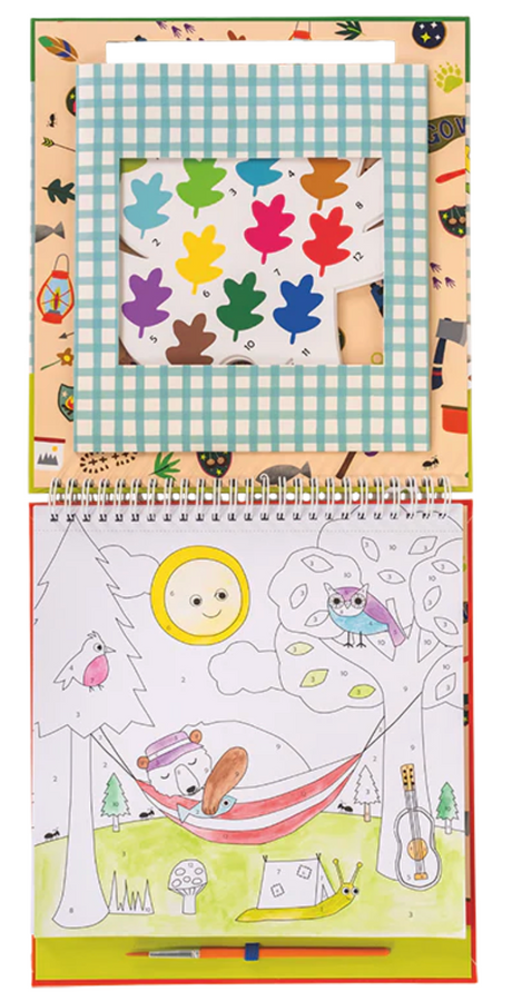 Open spiral-bound paint by numbers book showing a camping scene with animals and a numbered color palette shaped like leaves