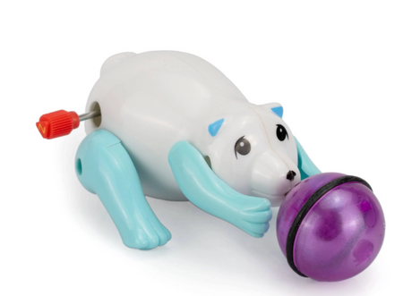 White and blue wind-up polar bear toy chasing a purple ball with a red winding key on its back