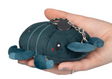 Hand holding a small, round plush stag beetle keychain with soft, dark blue fabric and a metal clip attached
