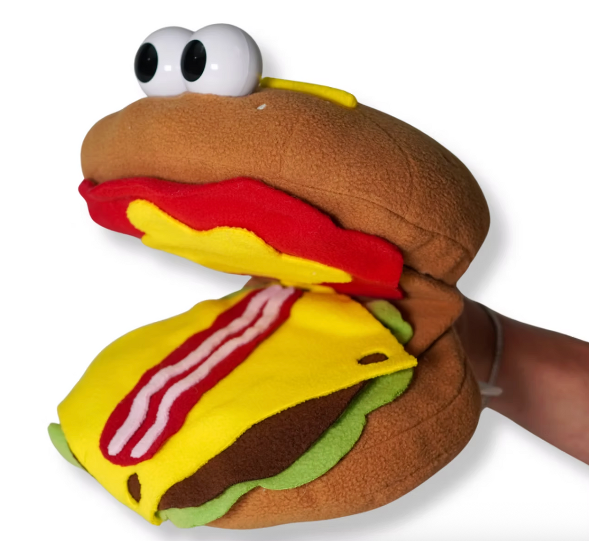 Hand puppet shaped like a hamburger with cheese, lettuce, bacon, and large cartoon eyes being worn on a hand