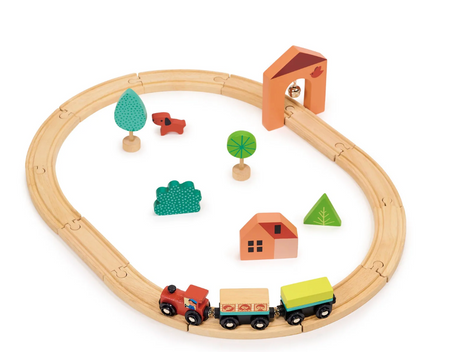 Wooden beginner train set with tracks, engine, carriages, tunnel, trees, house, and animal toys for young children.