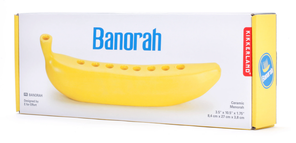 Ceramic menorah shaped like a yellow banana with eight candle holders and a friendly design on packaging box.