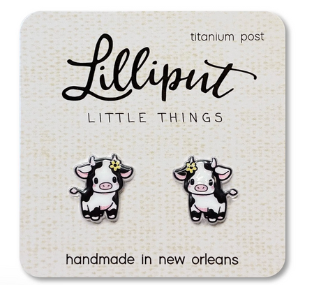 Cute baby cow stud earrings with titanium posts on a card, designed for sensitive ears and waterproof wear