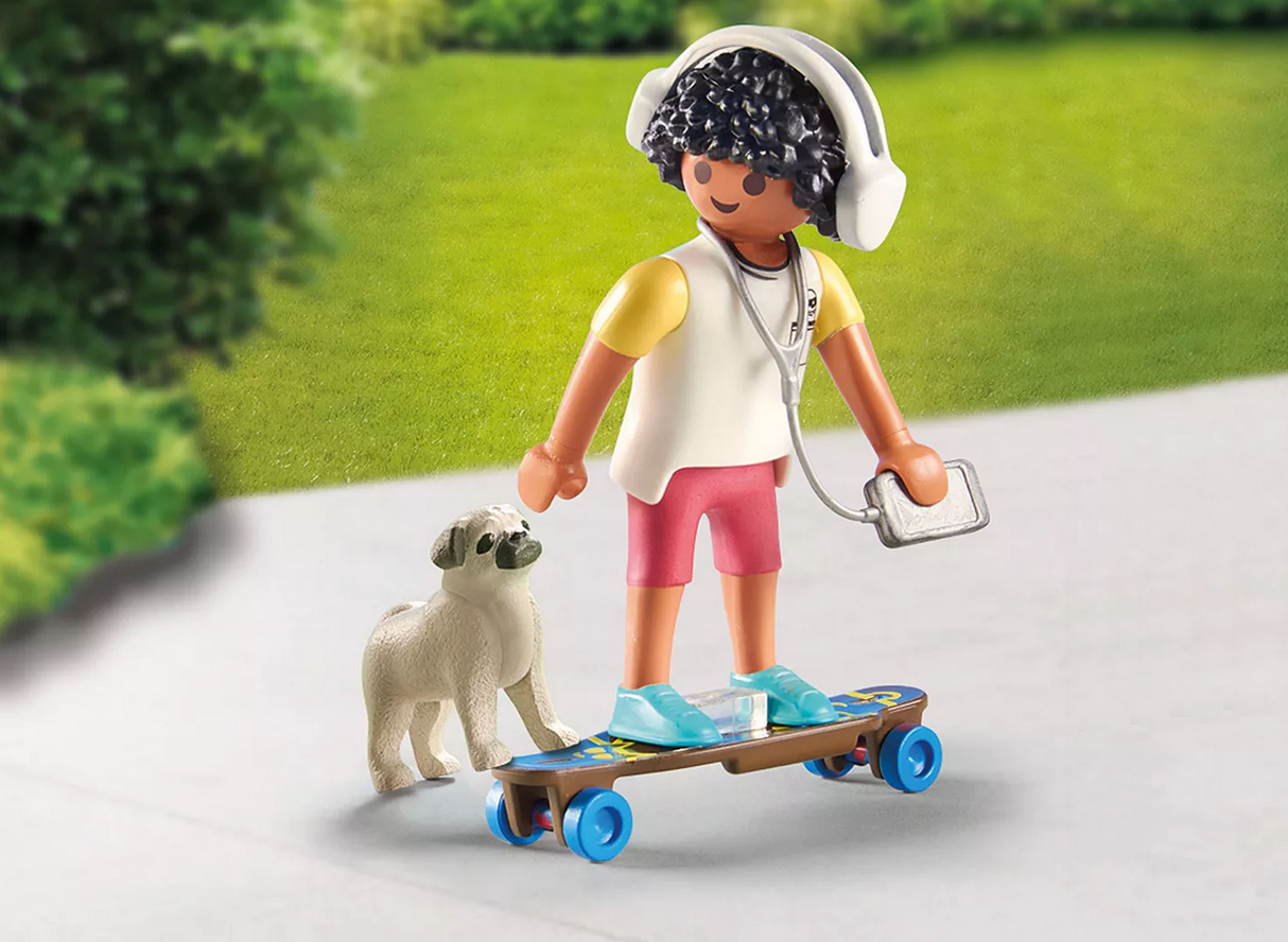 Toy figure with curly hair wearing headphones, standing on skateboard with small white dog on pavement outdoors