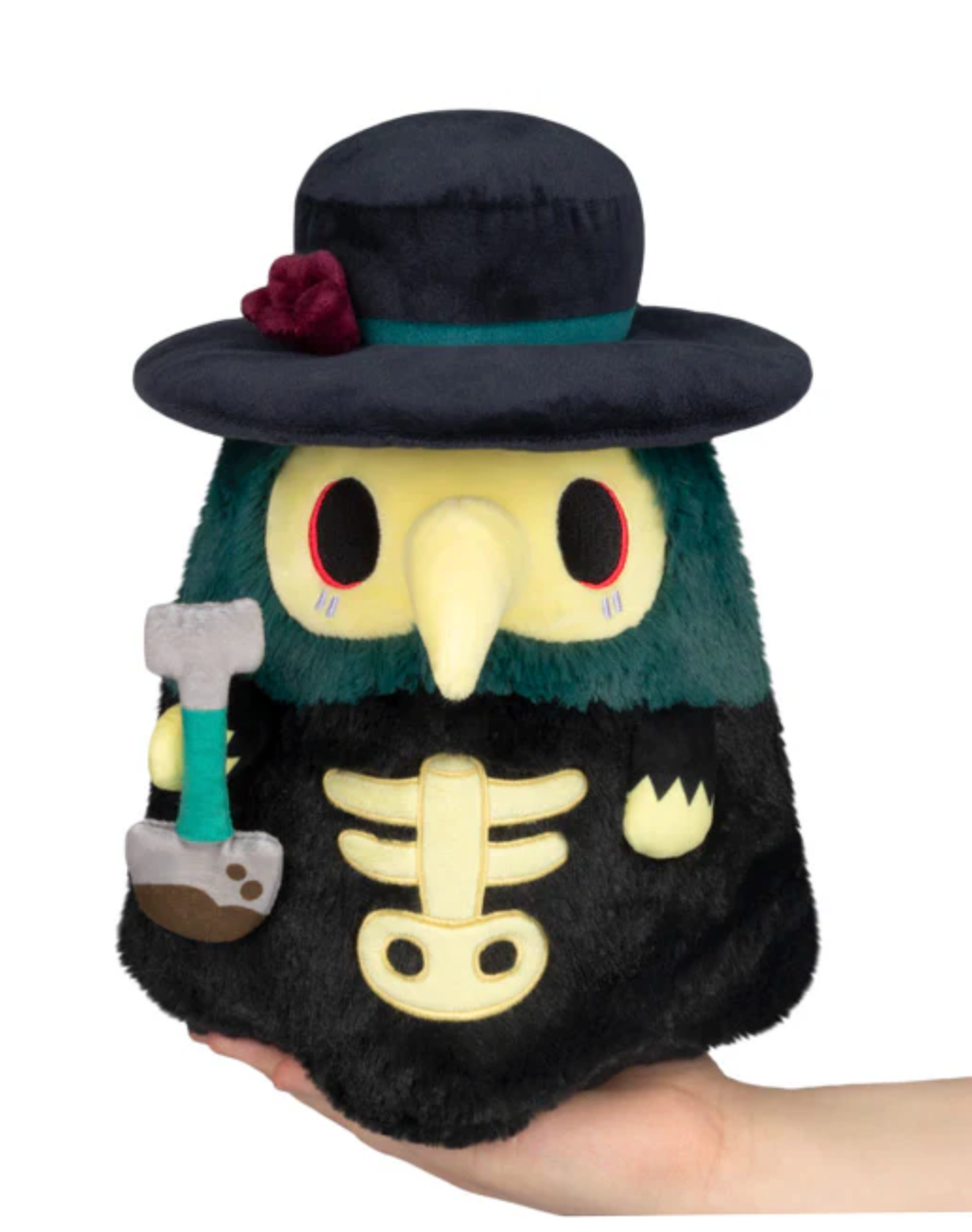 Plush toy of a dark green and black bird wearing a wide hat with a flower, holding a gray and teal hammer