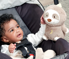 Lil Luvs On-the-Go Sloth Soother held by a smiling baby in a stroller
