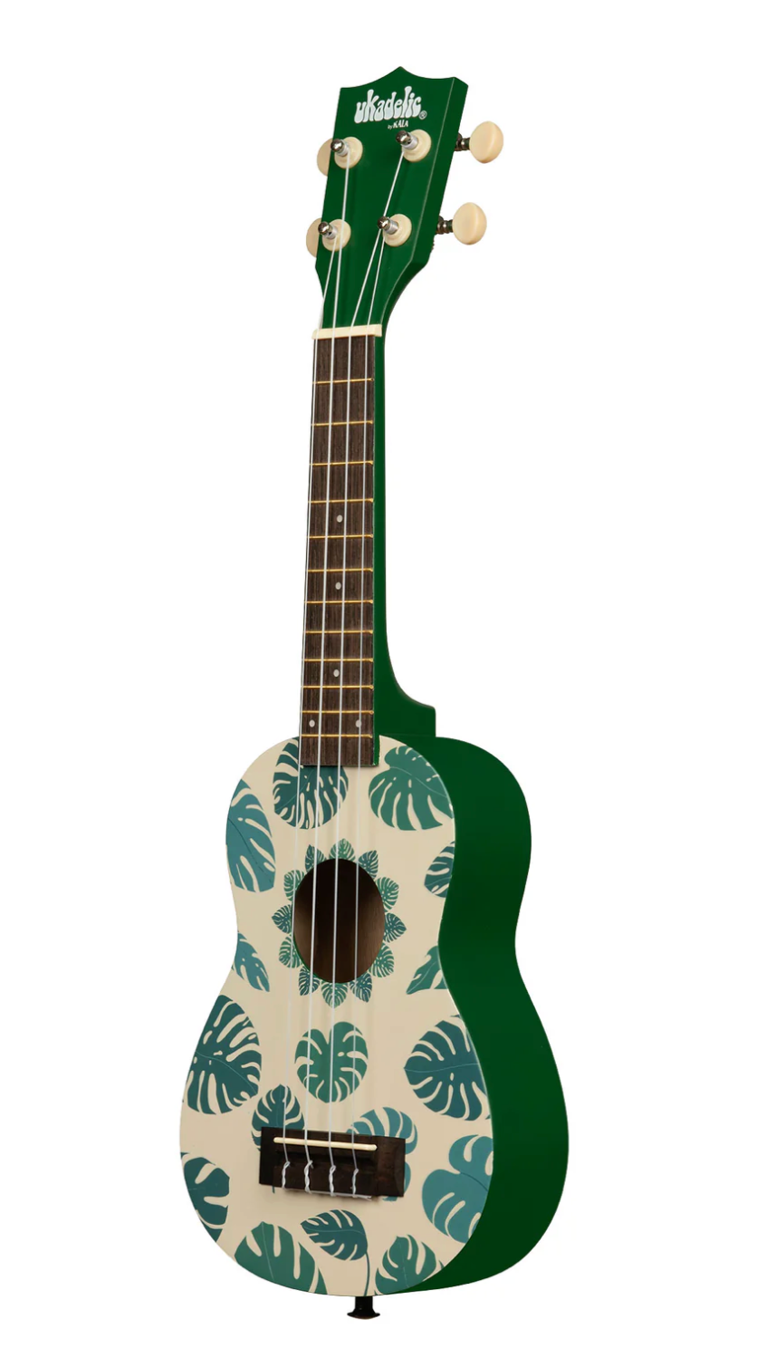 Small green ukulele with dark green tropical leaf pattern on cream front and light tuning pegs