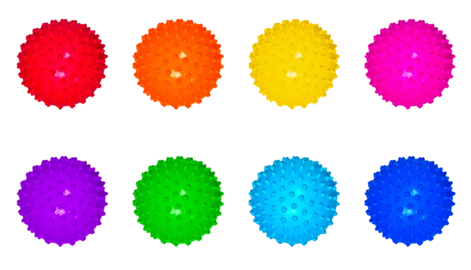 Eight small colorful textured balls with raised bumps arranged in two rows on a white surface