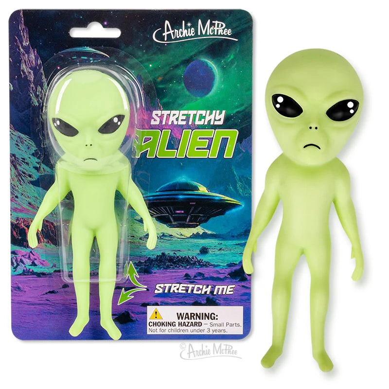 Green stretchy alien toy with large black eyes, displayed in packaging with space-themed background and UFO illustration.