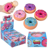 Colorful squishy donut toys with sprinkles displayed beside colorful retail boxes and a hand holding one donut