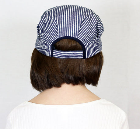 Back view of child wearing a striped Train Engineer Cap with adjustable strap for comfortable fit.