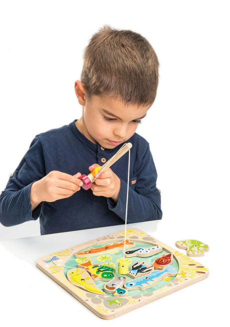 Child playing with the Pond Dipping wooden fishing set featuring colorful magnetized pond animals.