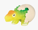 Colorful dinosaur hatching from a cracked white egg, a toy that grows when placed in water
