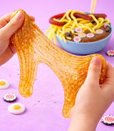 Ooey Gooey Slime Surprise golden glitter slime stretched between hands