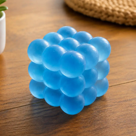 Feelzies Slow Flow Bubble Cube blue bubble cube toy on a wooden table