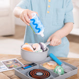 Child pretending to cook with Simmer Stir Stovetop Play Set pouring liquid onto colorful play food in pot